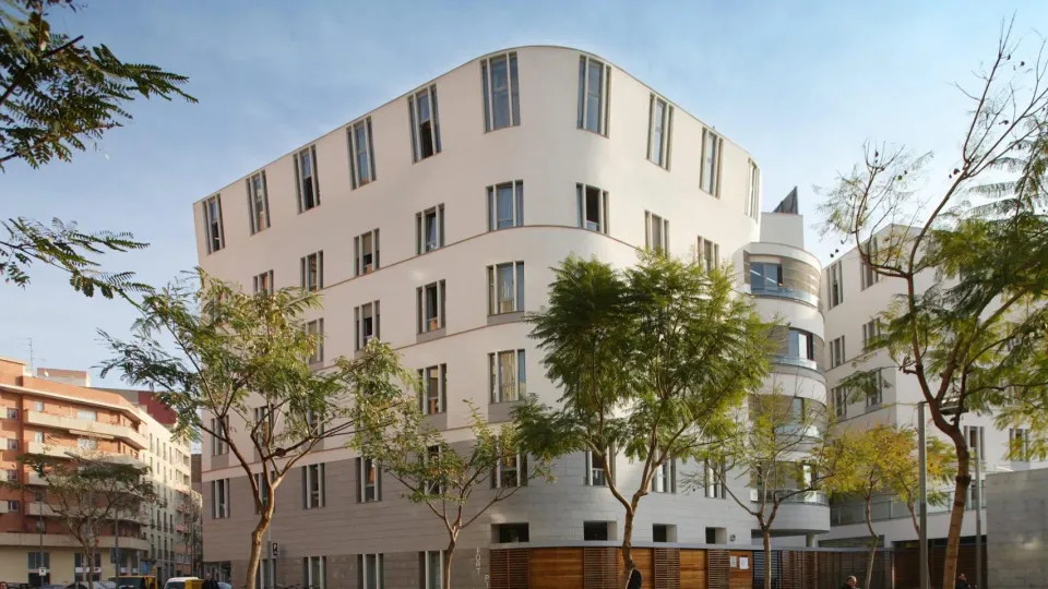 Exterior view of a multi-storey care home building in Barcelona, showing signs of wear and tear on its facade.