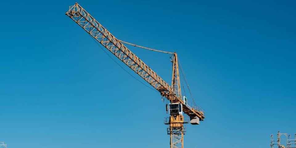 Emergency services personnel on a crane basket rescuing a man from a construction crane in Barcelona.