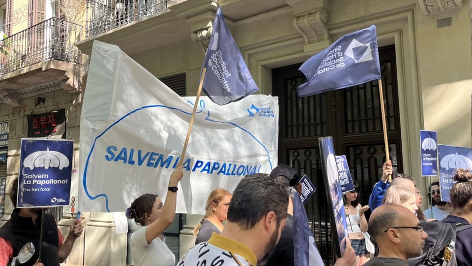 Protesters from the Socialist Housing Union of Catalonia holding banners outside the PSC Barcelona headquarters on Consell de