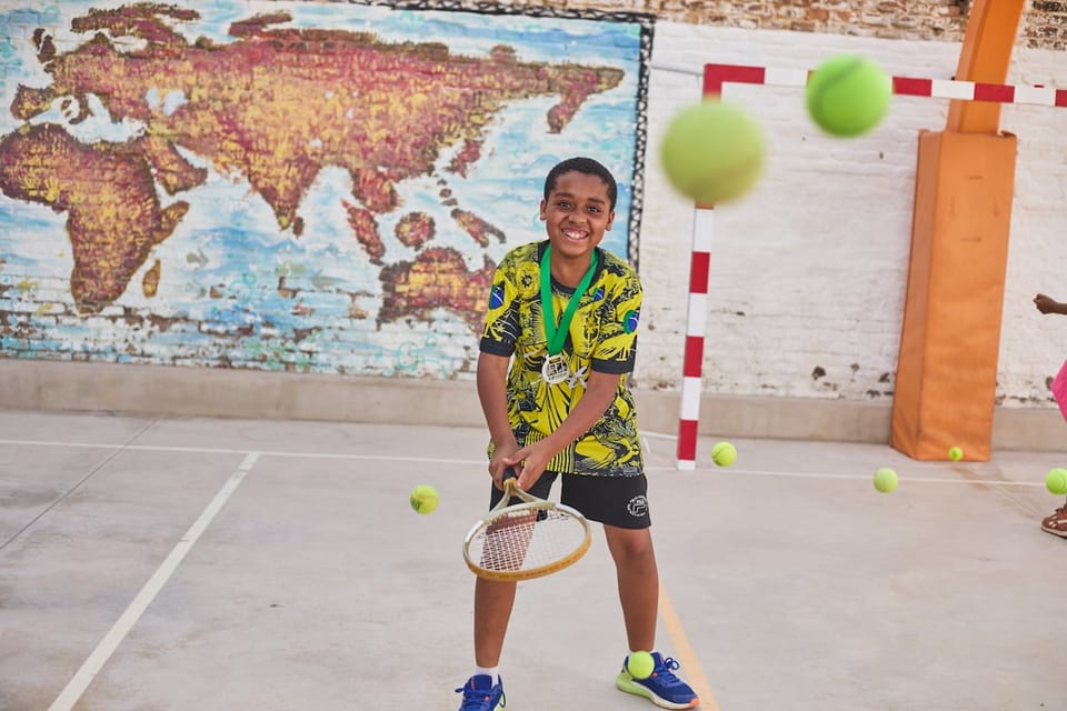 Young people hold tennis racquets on court at a Fundació Tennis Barcelona training session.