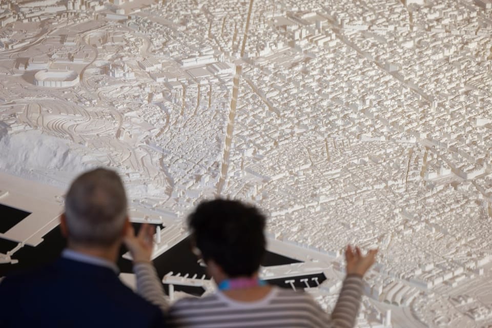 Architects gathered at a modern convention centre in Barcelona, discussing urban planning and sustainable design.