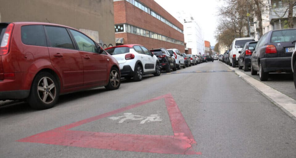 Children walking near a busy road with cars and buildings, showing air pollution haze in the background.