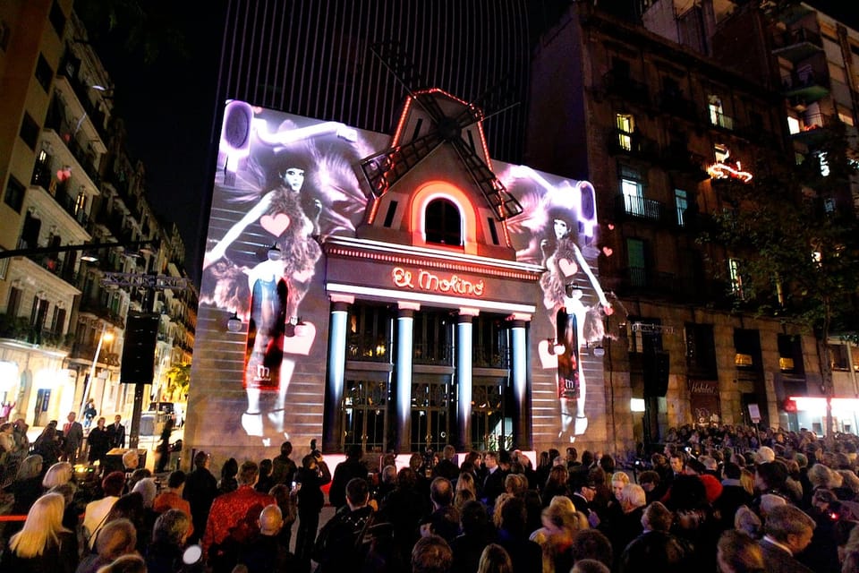 The iconic red windmill sign of El Molino theatre on Paral.lel avenue in Barcelona, with its distinctive facade.