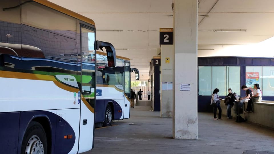 Exterior view of the Sants bus terminal in Barcelona, showing several intercity buses parked at platforms.