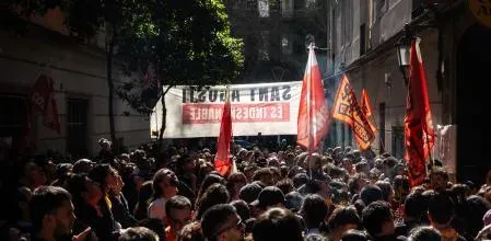 People protesting an eviction on a street in Barcelona's Gràcia neighbourhood, holding banners.