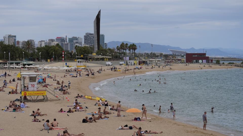 A street scene in Barcelona with historic buildings and people walking, representing urban exploration and tourism.