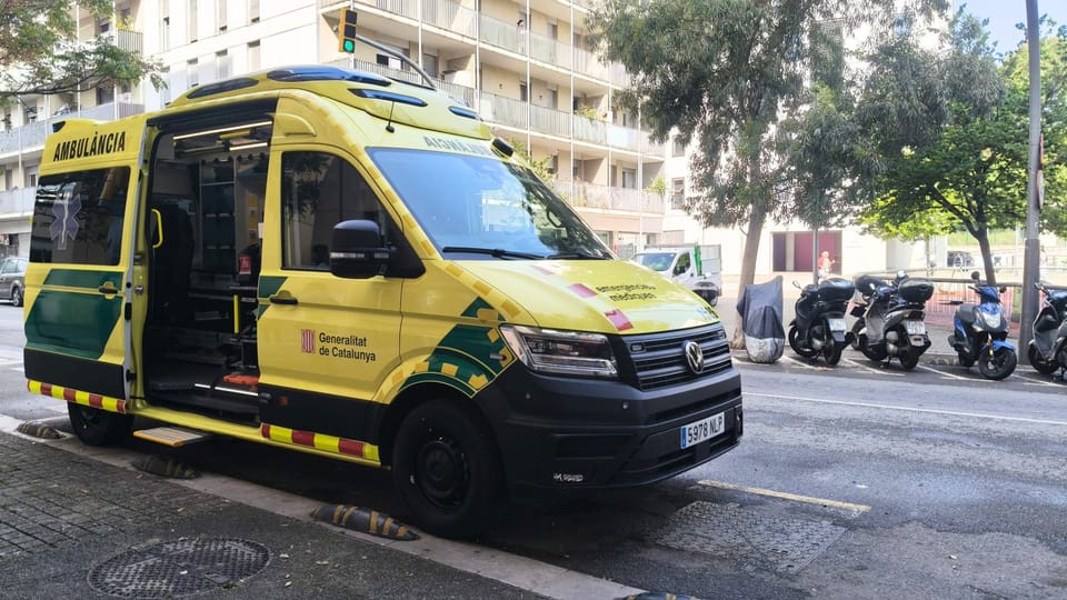 Ambulance parked outside a new emergency services base in Torre Baró, Barcelona, with residential buildings in the background