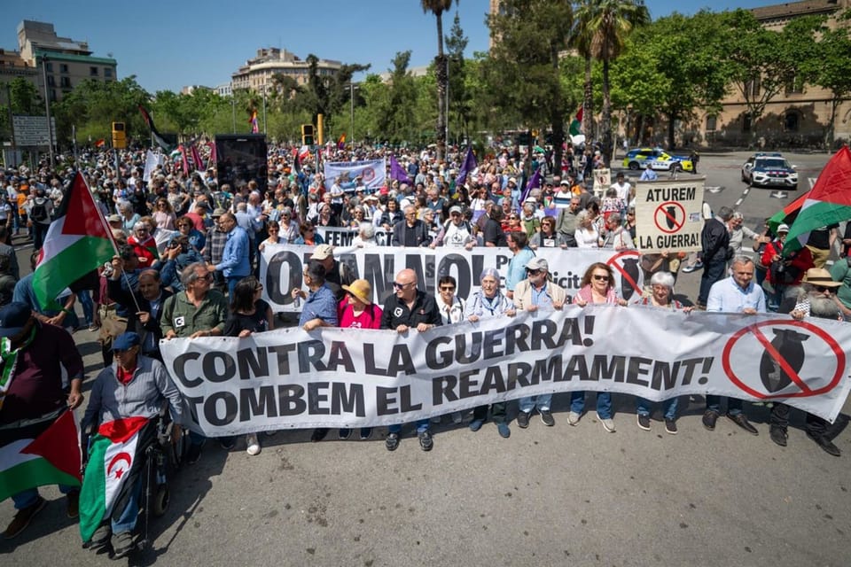 Protestors gather in Plaça Universitat, Barcelona, holding pro-Palestine banners.