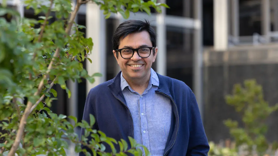 Gerardo Pisarello speaking at a political event in Barcelona, looking determined and engaging with an audience.