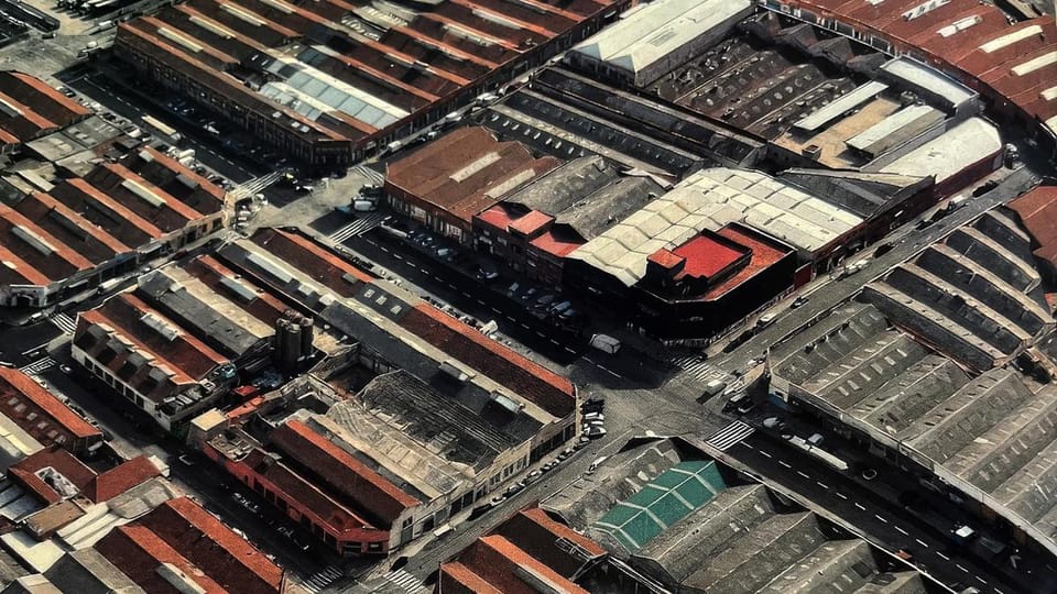 Aerial view of industrial estates in Sant Adrià de Besòs, showing warehouses, roads, and proximity to the Besòs river and urb