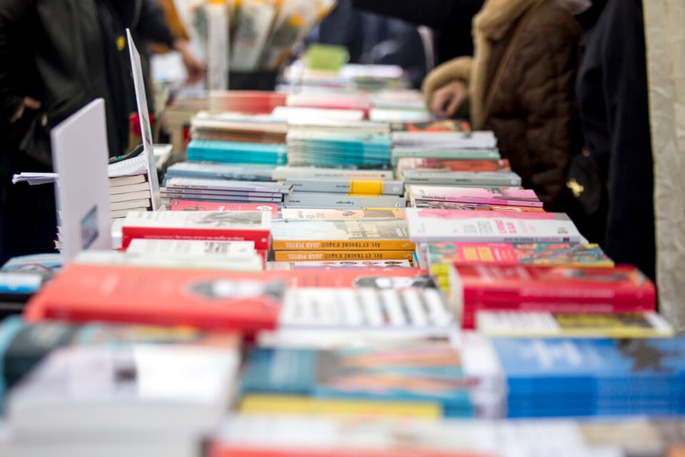 Stacks of books displayed at a Sant Jordi market stall in Barcelona.