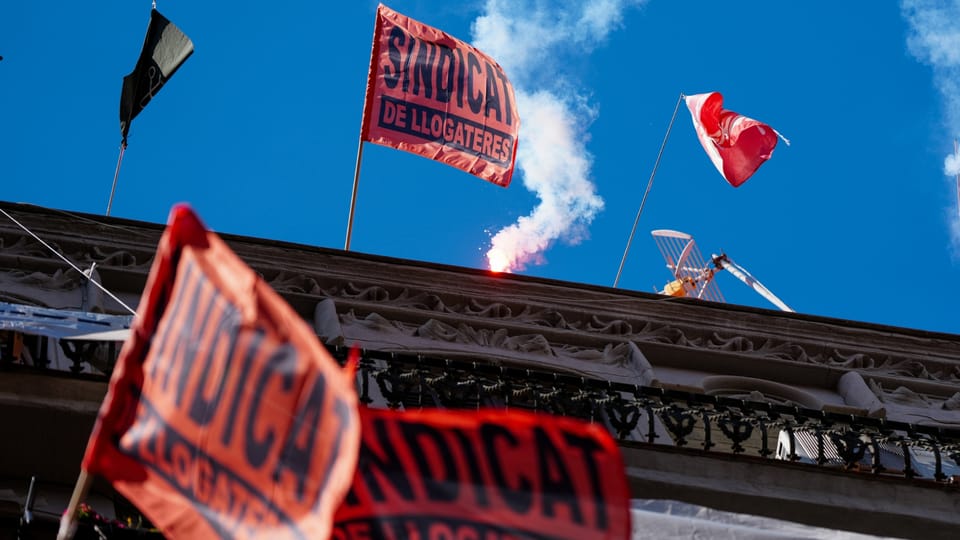 A protest sign in Catalan reading 'Stop Evictions' held by a person in a crowd, symbolising housing activism.