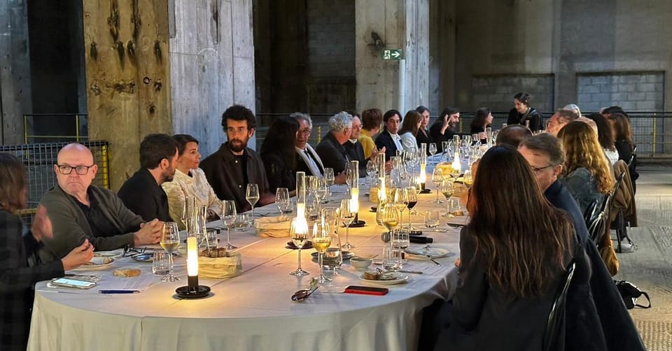 Architects and journalists dining inside the illuminated Tres Xemeneies power station in Sant Adrià de Besòs, Barcelona.