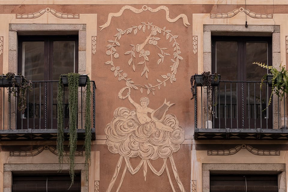 A detailed view of a Baroque sgraffito façade in Barcelona, showing intricate decorative patterns and figures.