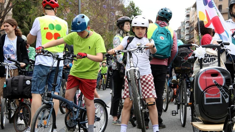 Families and children cycle through Barcelona streets during the Kidical Mass event.