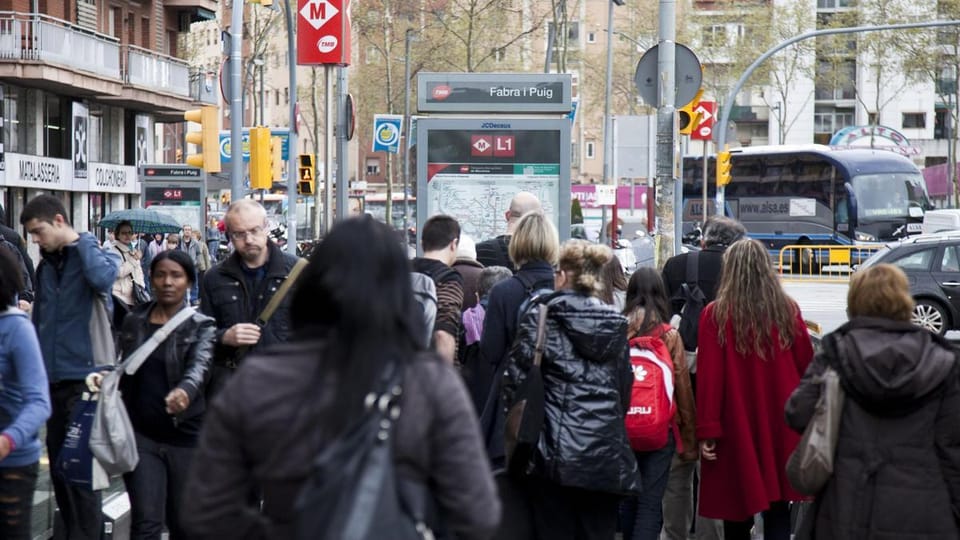 Crowded platform at Diagonal metro station in Barcelona with passengers waiting for a train.