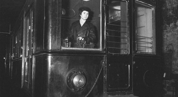 Vintage black and white photo of a Barcelona Metro train or station during the mid-20th century, showing people or wartime co