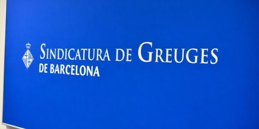 A close-up of the Barcelona City Council crest on a building facade, symbolising local governance and public institutions.