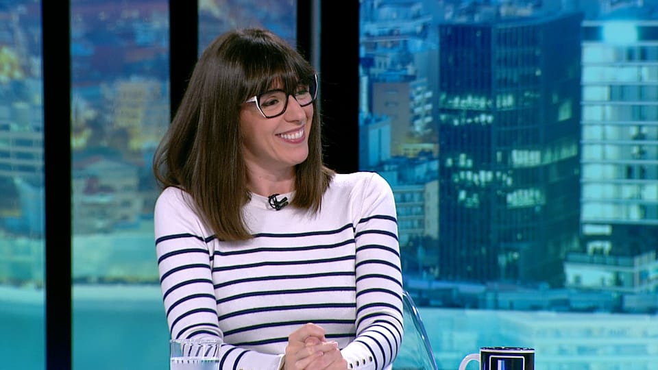 Elisenda Pineda, a Catalan screenwriter and TV personality, speaking during an interview on a television set.