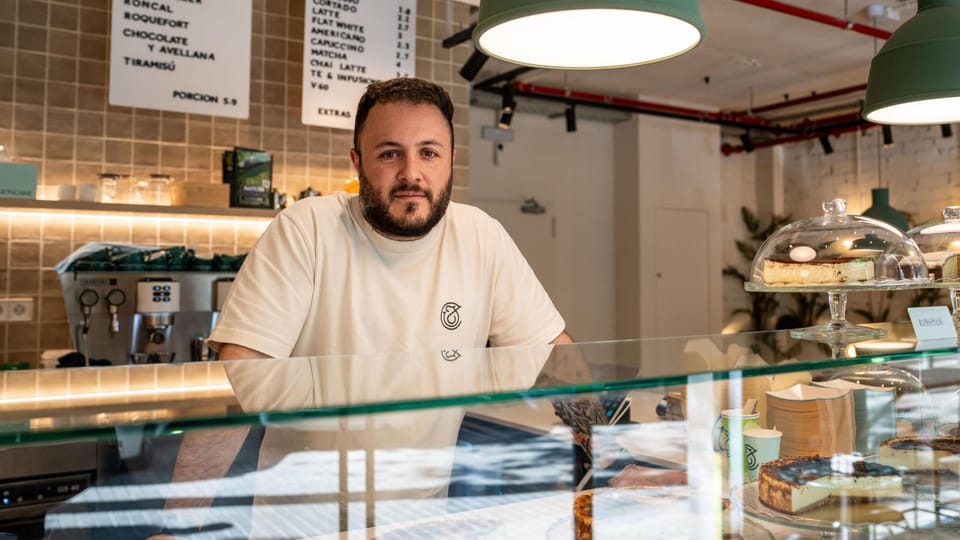 Jon García, founder of Jon Cake, stands proudly in his new Poblenou shop, surrounded by cheesecakes and savoury items.