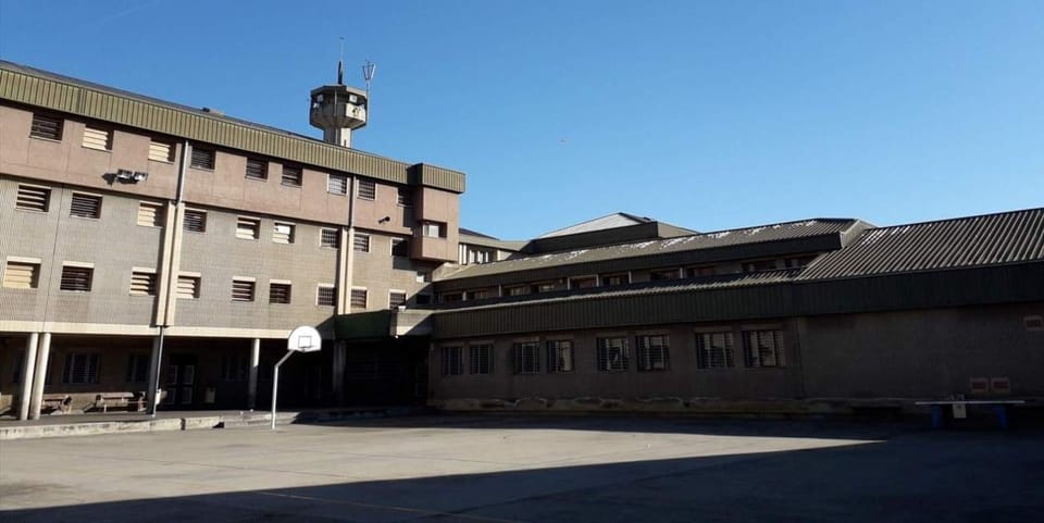 Exterior view of Quatre Camins prison in La Roca del Vallès, Catalonia, under a clear sky.