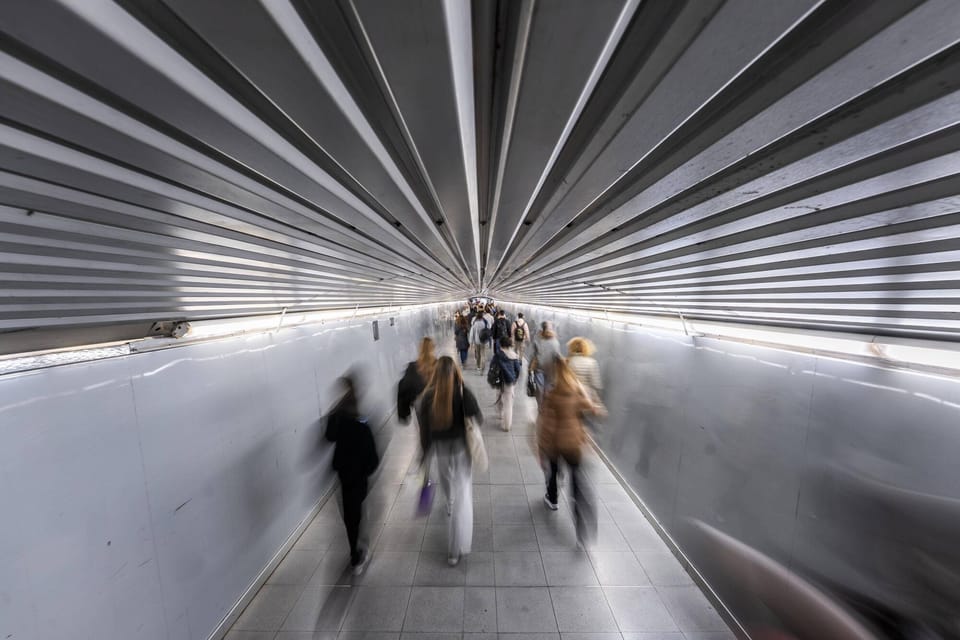Busy metro corridor at Plaça Catalunya station in Barcelona with many passengers walking.