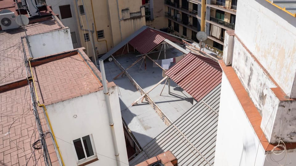 Exterior view of a building on Erasme de Janer street in Barcelona's Raval district, showing a handwritten "11 bis" on a lett