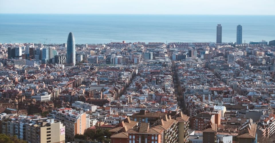 Barcelona's Poble-sec neighbourhood with residential buildings and Montjuïc mountain in the background.