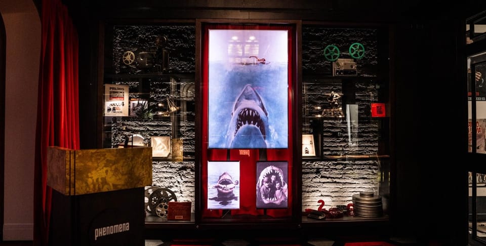 People watching a film in a dark cinema with a large screen showing movie credits