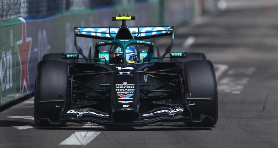 Fernando Alonso driving an Aston Martin Formula 1 car on the Circuit de Barcelona-Catalunya track.