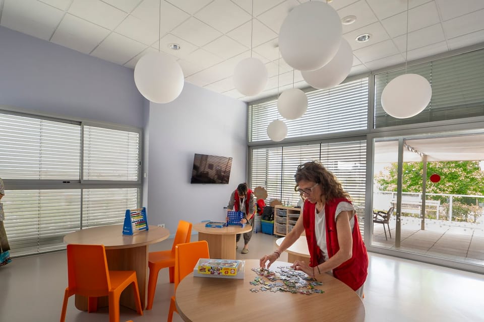 A family holding a baby's hand in a hospital room, symbolising palliative care and family support.