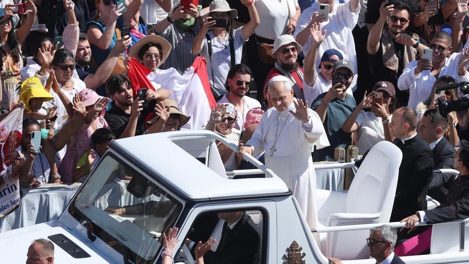 The Popemobile, covered by a tarpaulin, being transported by a crane from a military aircraft at El Prat Airport, escorted by