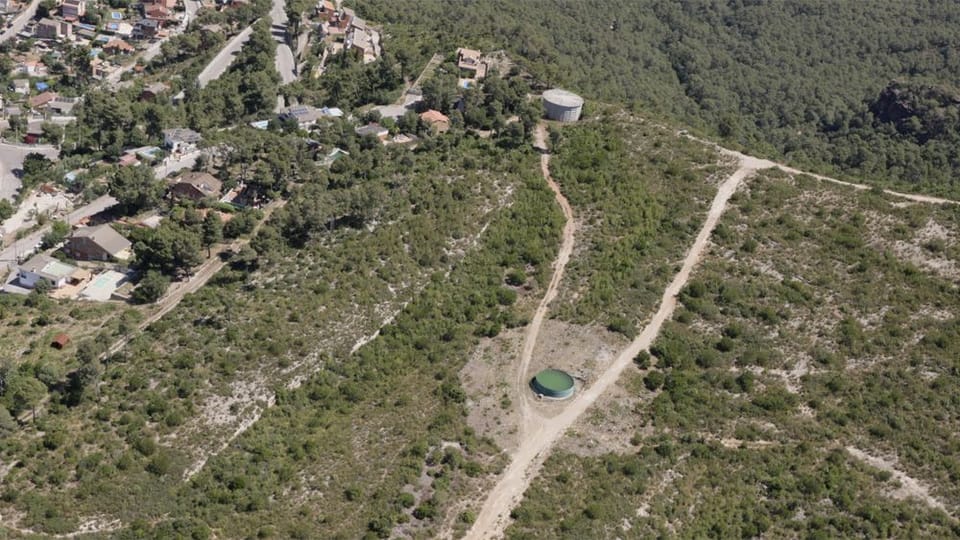 Forest rangers inspecting a wooded area in the Barcelona metropolitan region, with signs of illegal waste dumping nearby.