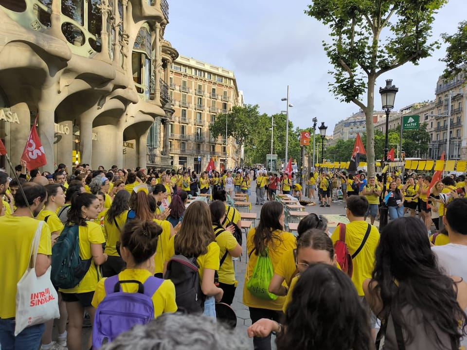 Teachers protesting with desks and chairs outside Casa Batlló in Barcelona.