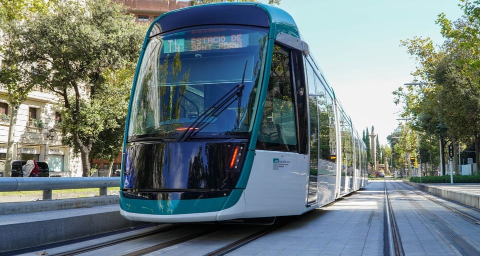 Trambesòs tram travelling along a street in Barcelona with buildings in the background