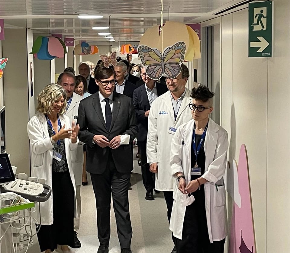 Exterior view of Vall d'Hebron Hospital in Barcelona with a new building rendering