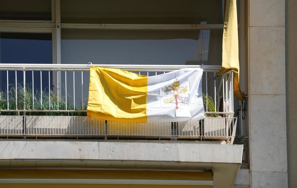 Sagrada Familia with a Catalan flag on its tower, representing the request for Catalan prayer.