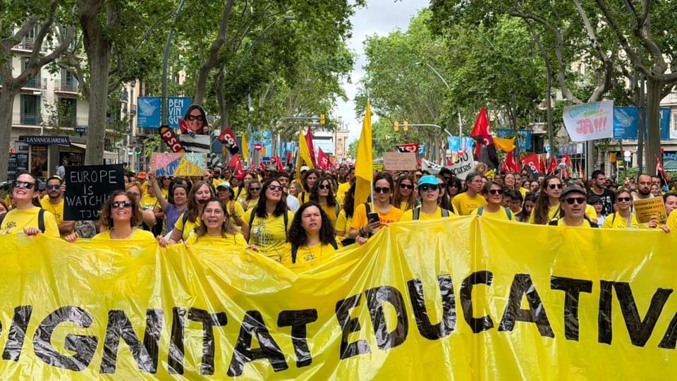 Thousands of teachers march through Barcelona, holding banners and flags, protesting against the education agreement.