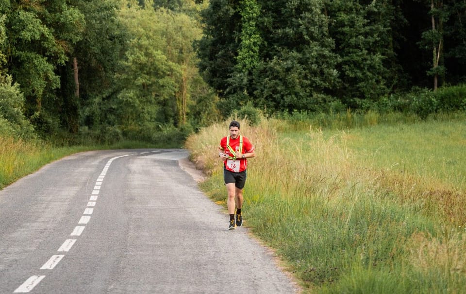 Ultra-runner traversing a mountain trail with the Catalan Pyrenees in the background