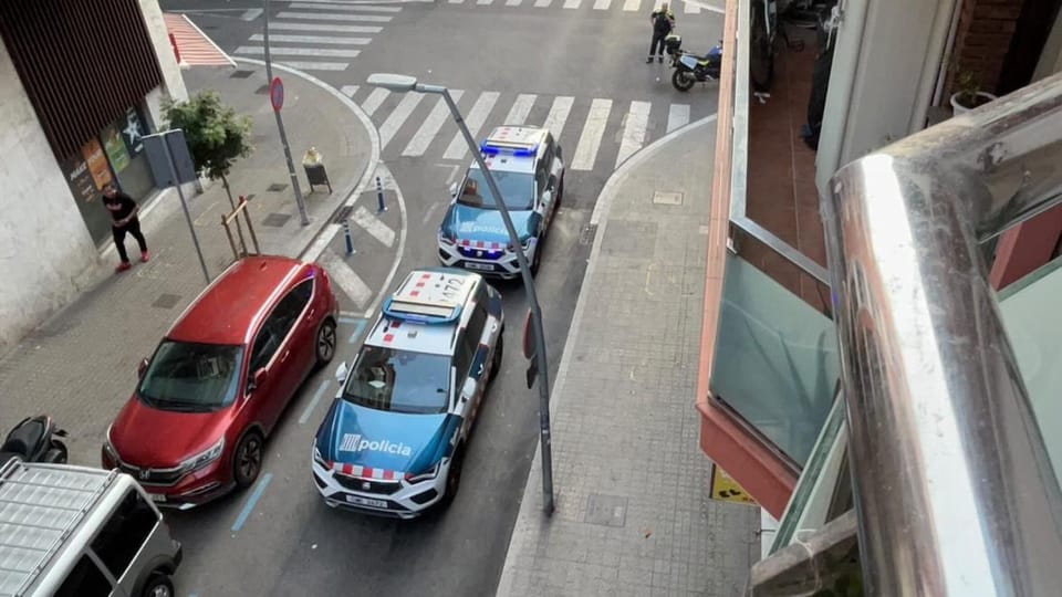 Police vehicles and officers from Mossos d'Esquadra and Guardia Urbana outside Bar Josué in L'Hospitalet de Llobregat.