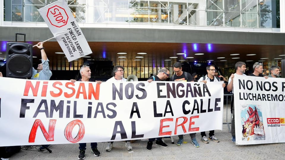 Nissan workers protest in Barcelona city centre, holding banners and flags.