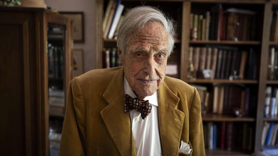 Oriol Domènec Llavallol, a 102-year-old man, sitting in his Barcelona home surrounded by photos and books.